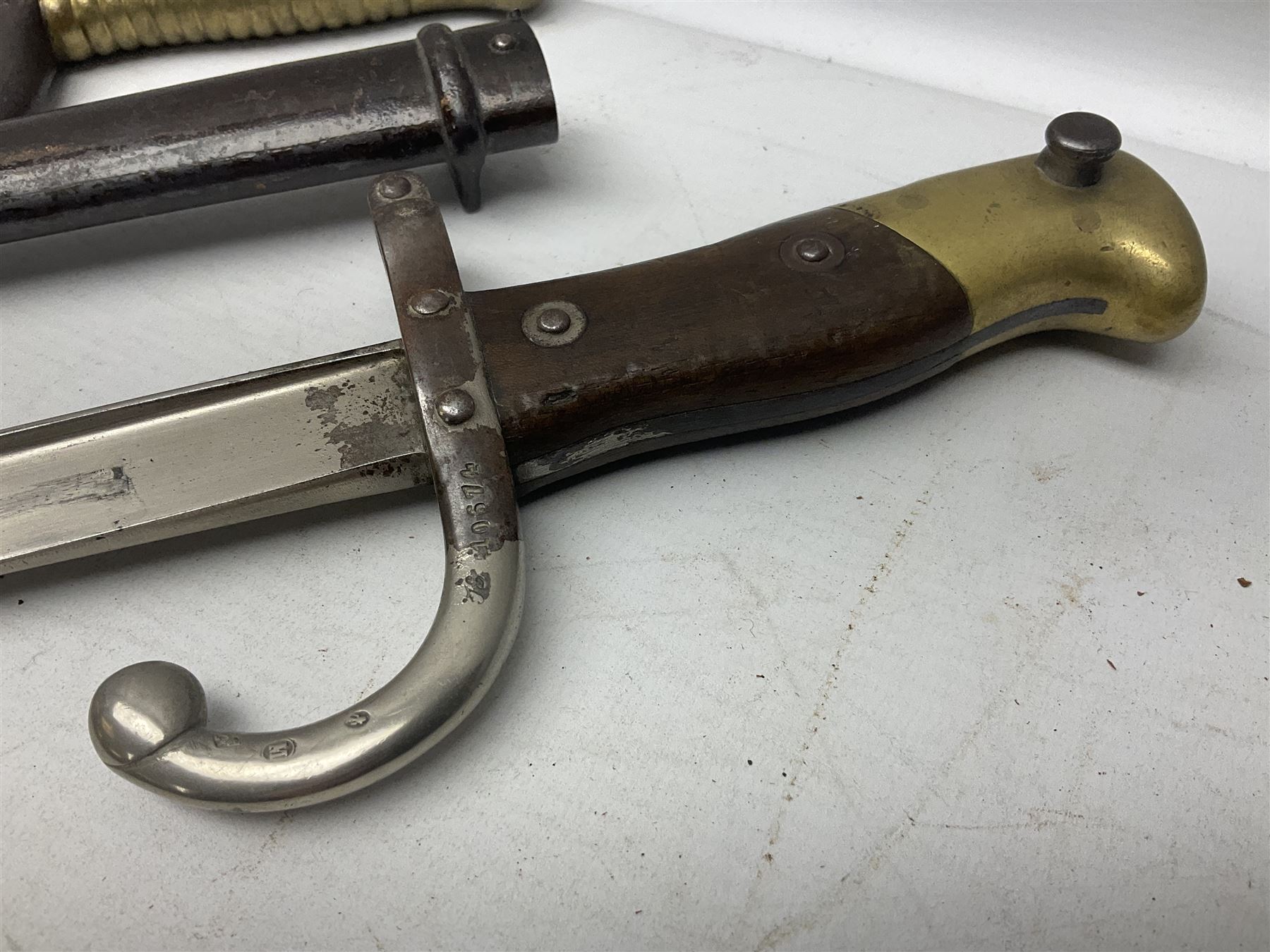 French Model 1866 Chassepot bayonet with 57cm curving fullered steel blade dated 1873 No.L63963; in steel scabbard with conforming number L71.5cm overall; and French St. Etienne Gras bayonet dated 1878 No.K10674 in steel scabbard numbered 79437 (2)