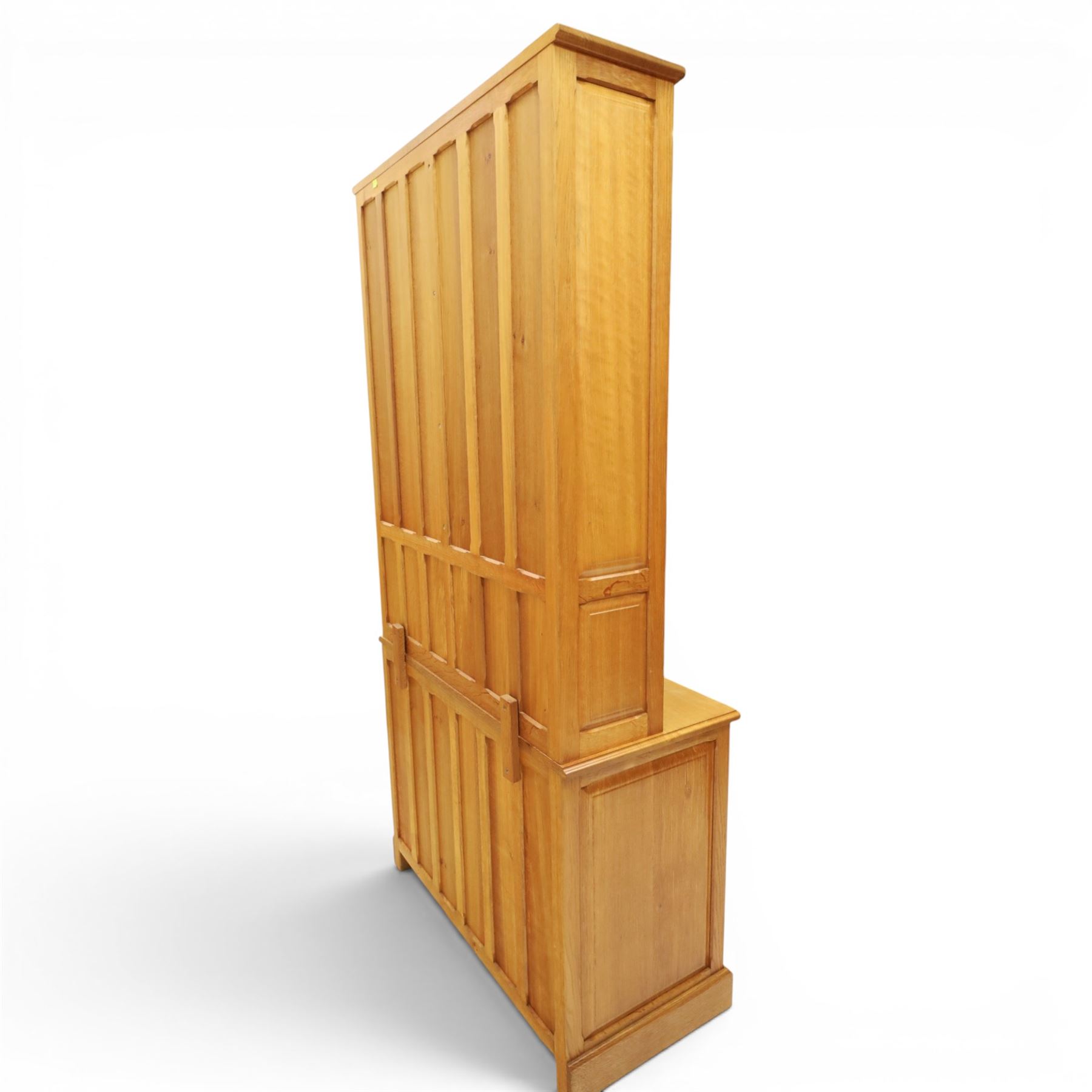 Knightman - oak dresser, the upper section fitted with twin glazed doors enclosing glass shelves, over open recess with panelled back, the base fitted with two drawers over twin panelled cupboards enclosing shelves, with recessed carved knight trademark, by Horace Knight of Old Mill Furniture, Balk near Thirsk