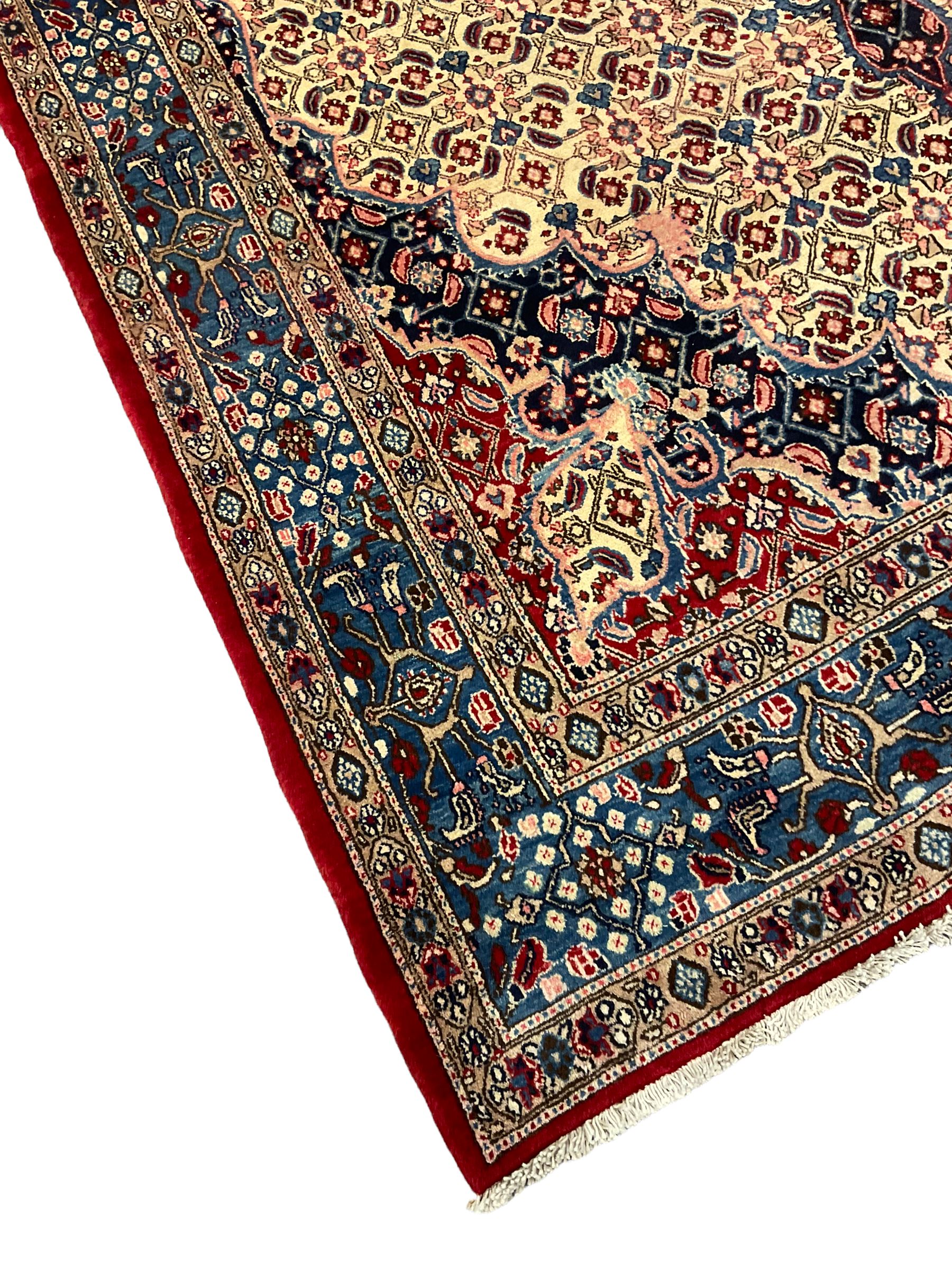 Persian Moud carpet, the field decorated all-over with Herati motifs, central medallion and spandrels decorated with stylised plant and flower head motifs, repeating border with guard