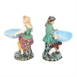 Pair of Minton majolica Hogarth figures, modelled as a seated boy and girl, on tree stumps, both holding sweetmeat dishes, with impressed marks beneath, H18cm 