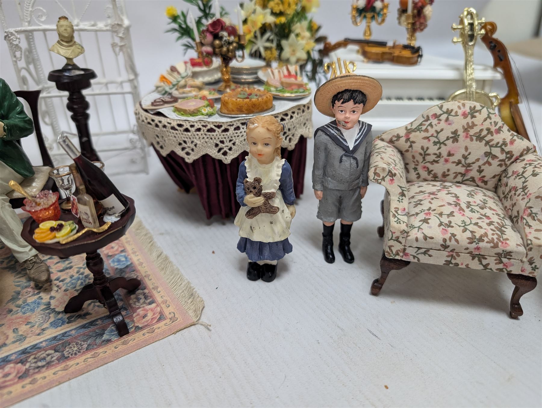 Dolls house furniture, including pianos, fireplace, plants, flower arrangements, tables, chairs, six figures and a collection of instruments and other accessories