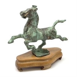 A 20th century Chinese bronzed Flying Horse of Gansu, modelled upon a flying swallow, on wooden base, horse L19cm. 