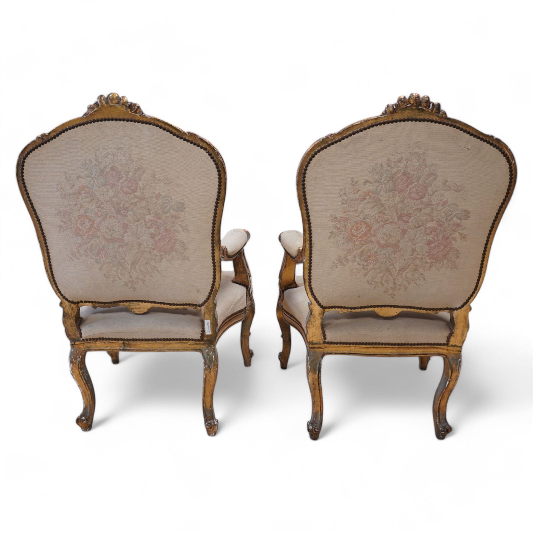 Pair of Louis XV design gilt framed armchairs, shaped cresting rail decorated with shells and foliage, upholstered in floral pattern fabric, on shell carved cabriole front supports 