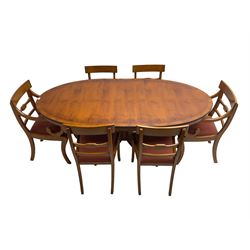 Regency design yew wood dining table, oval cross-banded top with reeded edge, raised on turned pedestal with reeded sabre supports terminating in brass hairy paw feet and castors (W138cm D100cm H75cm); and Rackstraw - set six (4+2) Regency design dining chairs with red drop-in seats (W50cm H86cm)