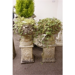  Pair ornate composite campana shaped stone urns, on square columns depicting a small boy under an arch, W48cm, H96cm  