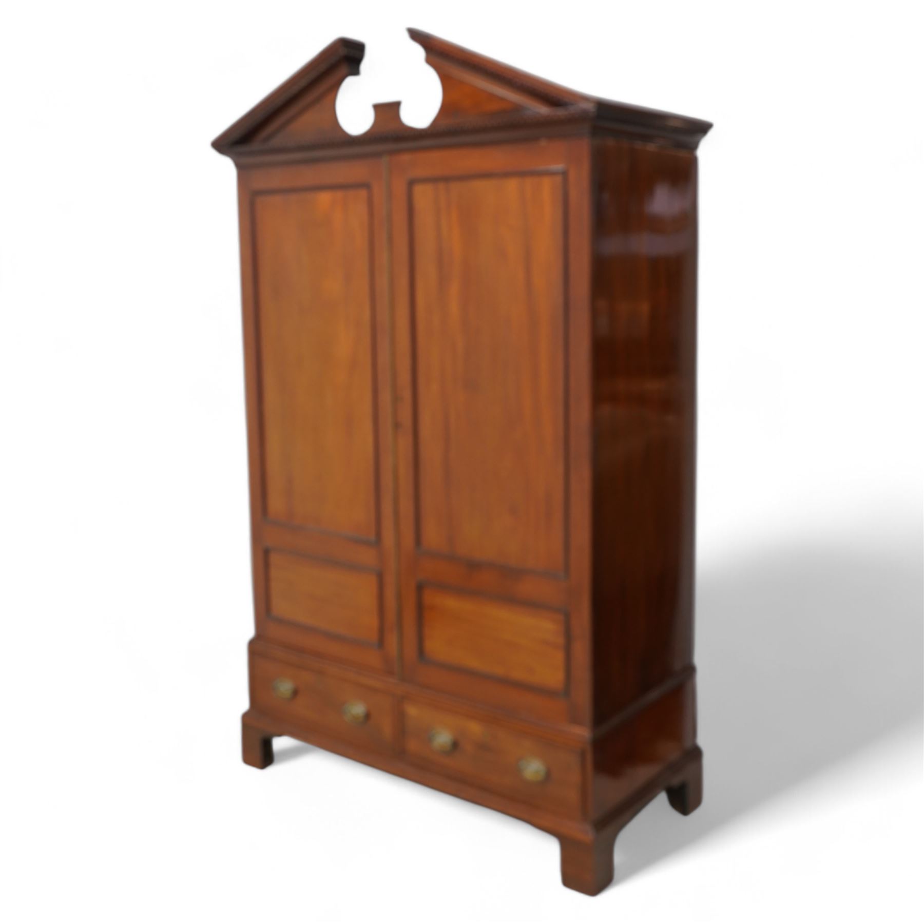George III mahogany wardrobe, broken sloped arch pediment with dentil moulding over two panelled doors, the base fitted with two cock-beaded drawers, on bracket feet, knock-down construction 