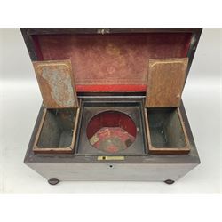 Early 19th century rosewood tea caddy, of sarcophagus form with twin lion mask ring handles, upon four compressed bun feet, the hinged cover opening to reveal a central recess for mixing bowl (now lacking), and two removable compartments