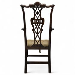 19th-century Chippendale Revival design mahogany oversized high-back armchair, serpentine crest carved top rail above pierced back splat with interlaced ribbon carving and geometric fretwork design, and outward scrolling arms above drop-in needlework seat on square chamfered legs 