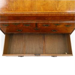 18th century figured walnut bureau, the sloped fall-front enclosing fitted interior with sliding base, pigeon-holes and correspondence drawers with shaped facias, over two short and two long feather-banded drawers with pressed brass handle plates, on bracket feet