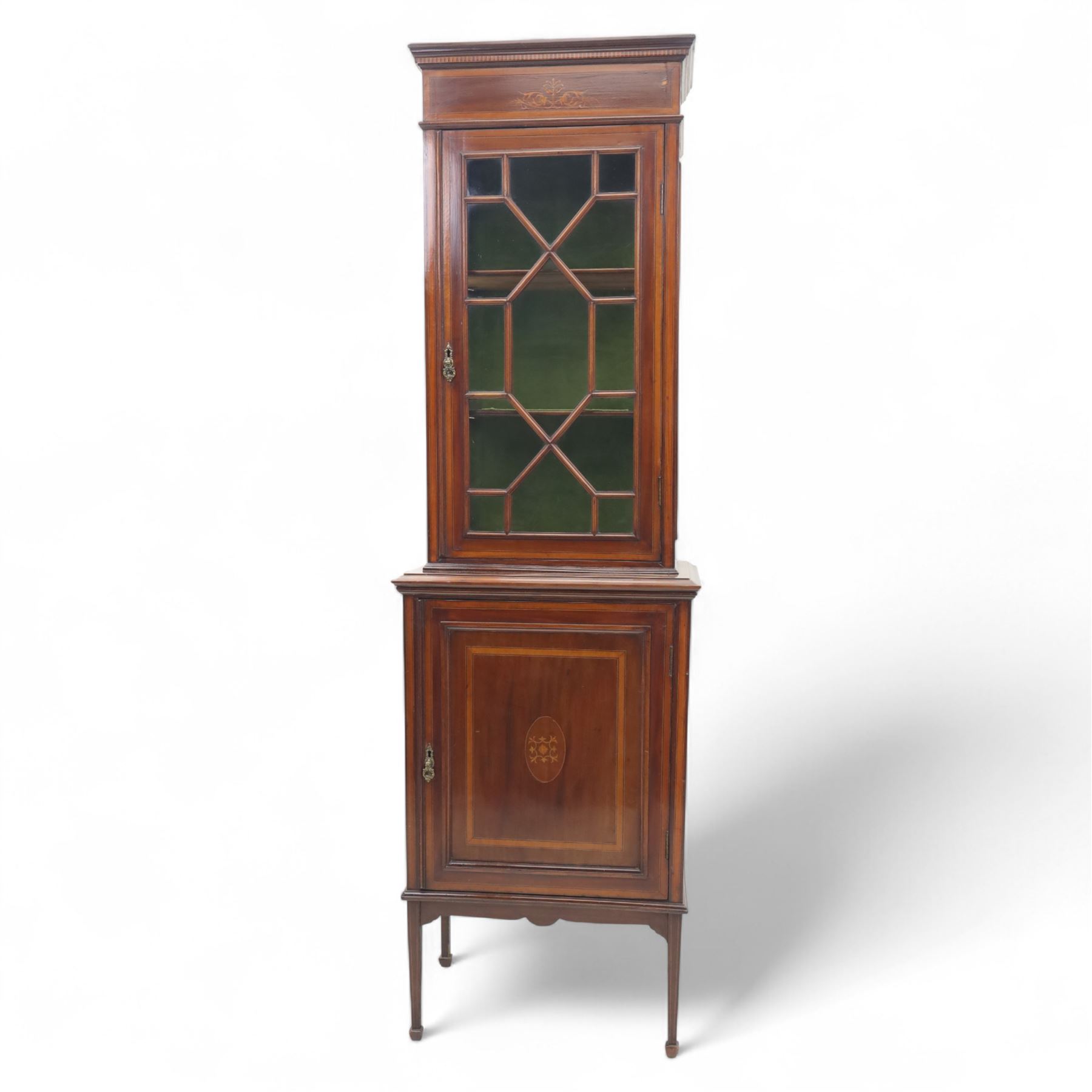 Edwardian inlaid mahogany display cabinet, the moulded cornice above an astragal glazed door enclosing two baize lined shelves, the lower section with a panelled cupboard door, raised on square tapering supports