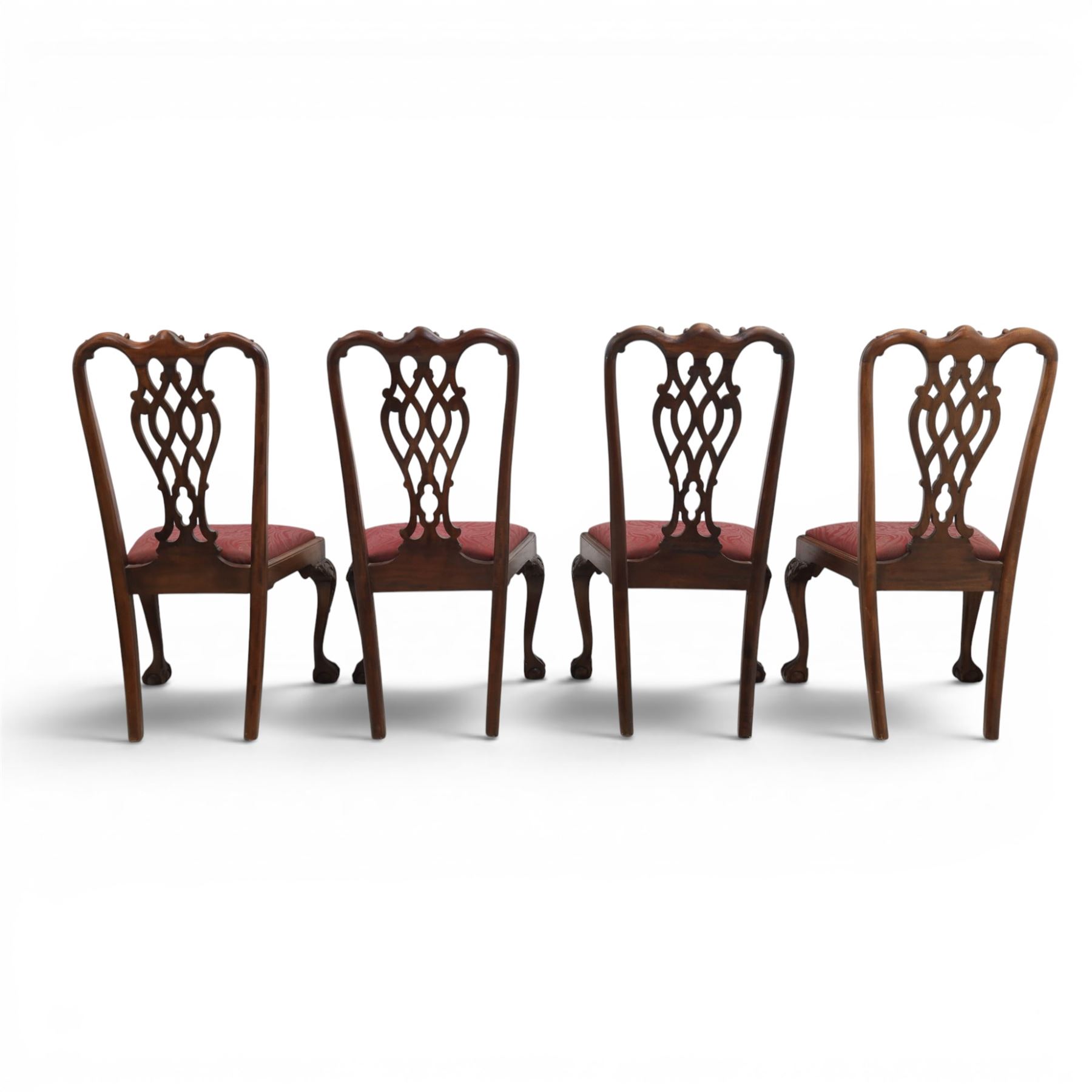 Chippendale design set of ten (8+2) mahogany dining chairs, serpentine cresting rails with carved detail over pierced ribbon-tied splats, red damask upholstered drop-in seats, on cabriole supports with acanthus carved knees and claw and ball feet