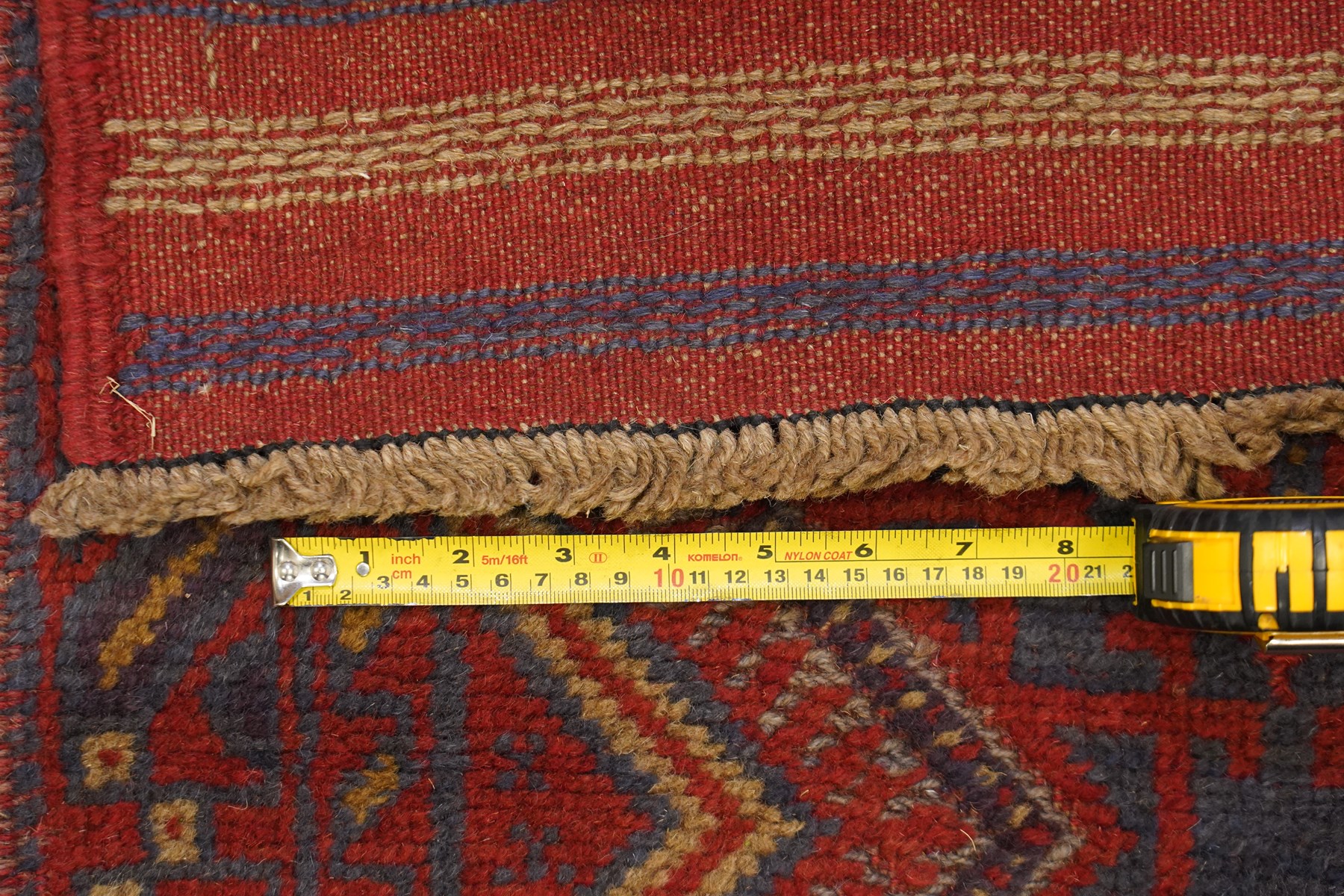 Near pair of Afghan Meshwani runner rugs, each with four red lozenge medallions on a blue ground interspersed with hooked geometric motifs, enclosed by patterned red borders, striped kilim end panels (2)