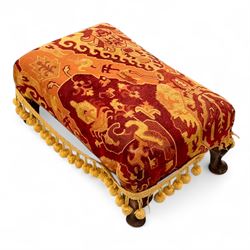 20th century Georgian style upholstered wingback armchair with footstool, the chair in yellow and red plaid fabric, the stool with fringed tapestry cover