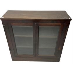 Edwardian mahogany enclosed bookcase, fitted with two glazed doors enclosing two shelves, flanked by reeded uprights, on skirted base