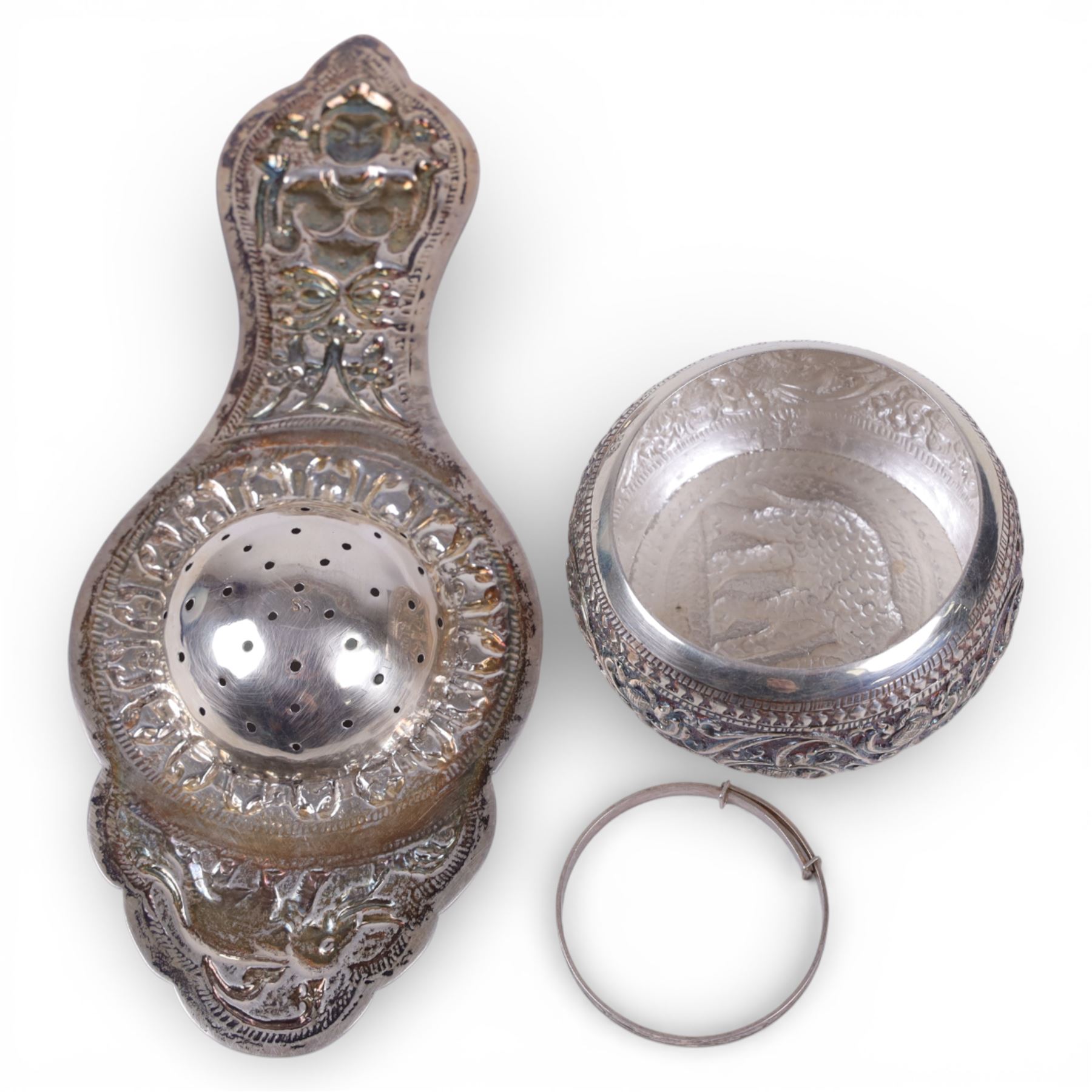 Sri Lankan silver tea strainer and bowl, embossed with elephant decoration and a silver child's bangle