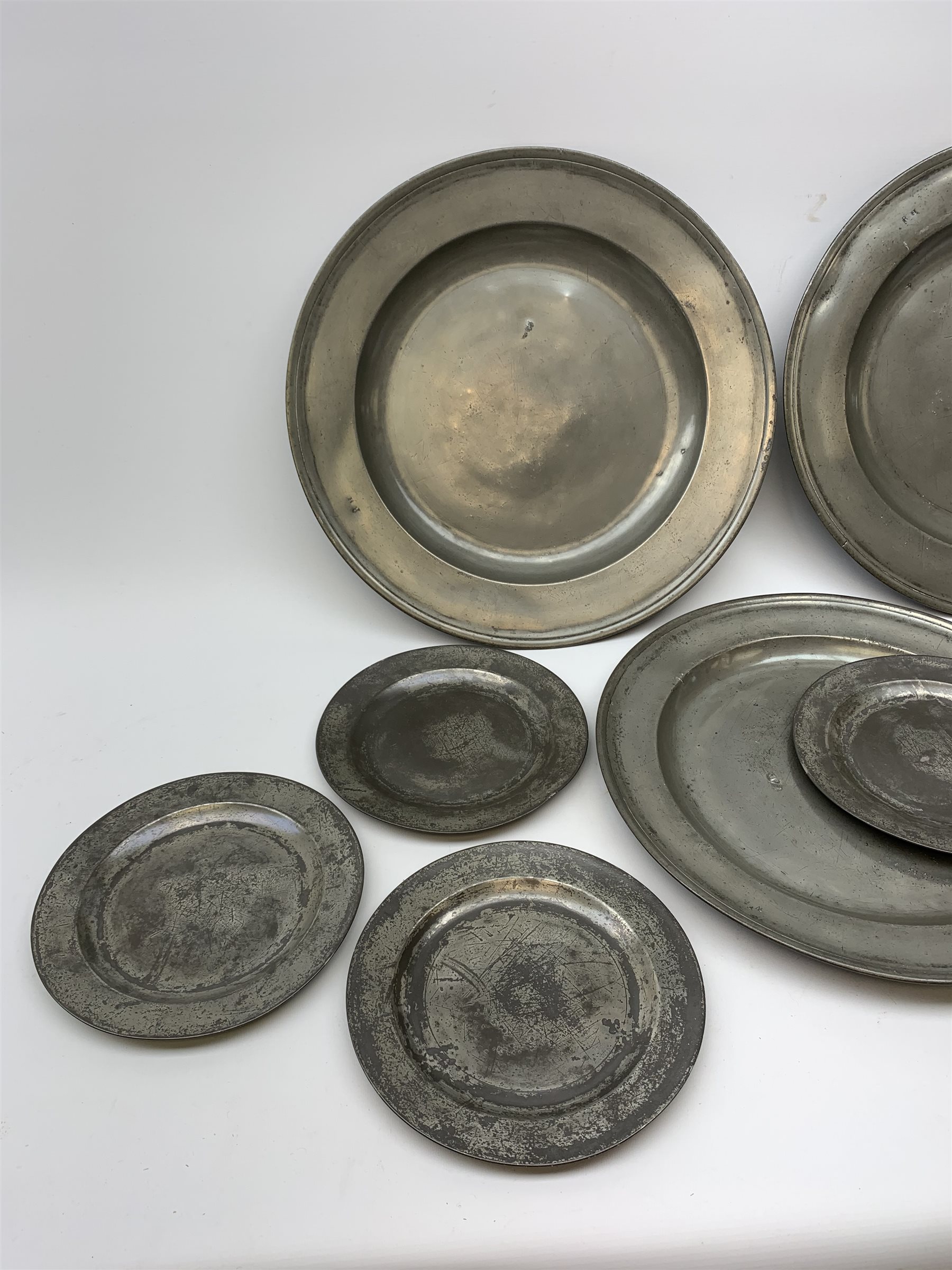 Collection of early 18th century pewter, comprising three large chargers, and seven plates, with various marks and touch marks verso, including the Crowned Rose and shield pseudo 'hallmarks', chargers D46cm and D42cm, plates D23cm.