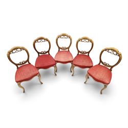 Set of five Victorian mahogany dining chairs, the scalloped balloon back with pierced scrolling acanthus leaf decoration, sprung seats upholstered in crimson fabric, on cabriole supports
