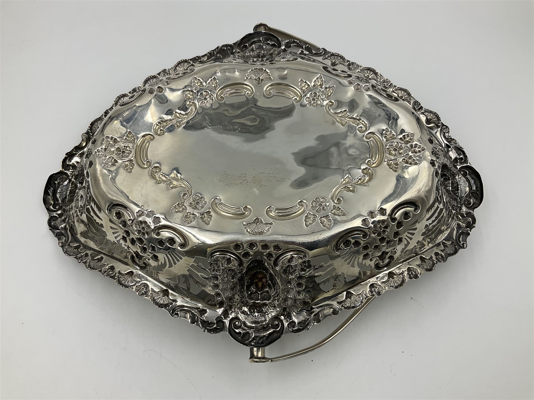 Edwardian silver swing handled basket, of navette form, with four repousse lion masks to each corner and with pierced and embossed floral, scroll and shell decoration to sides, base and handle, hallmarked Charles Horner, Birmingham 1906, height including handle H20cm