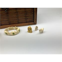 Bamboo box containing Japanese celluloid rickshaw group, small porcelain figure of a young girl playing cymbals; Japanese bamboo fan depicting Mount Fujiama; and various resin and bone items including bracelet, small lidded box, figures etc