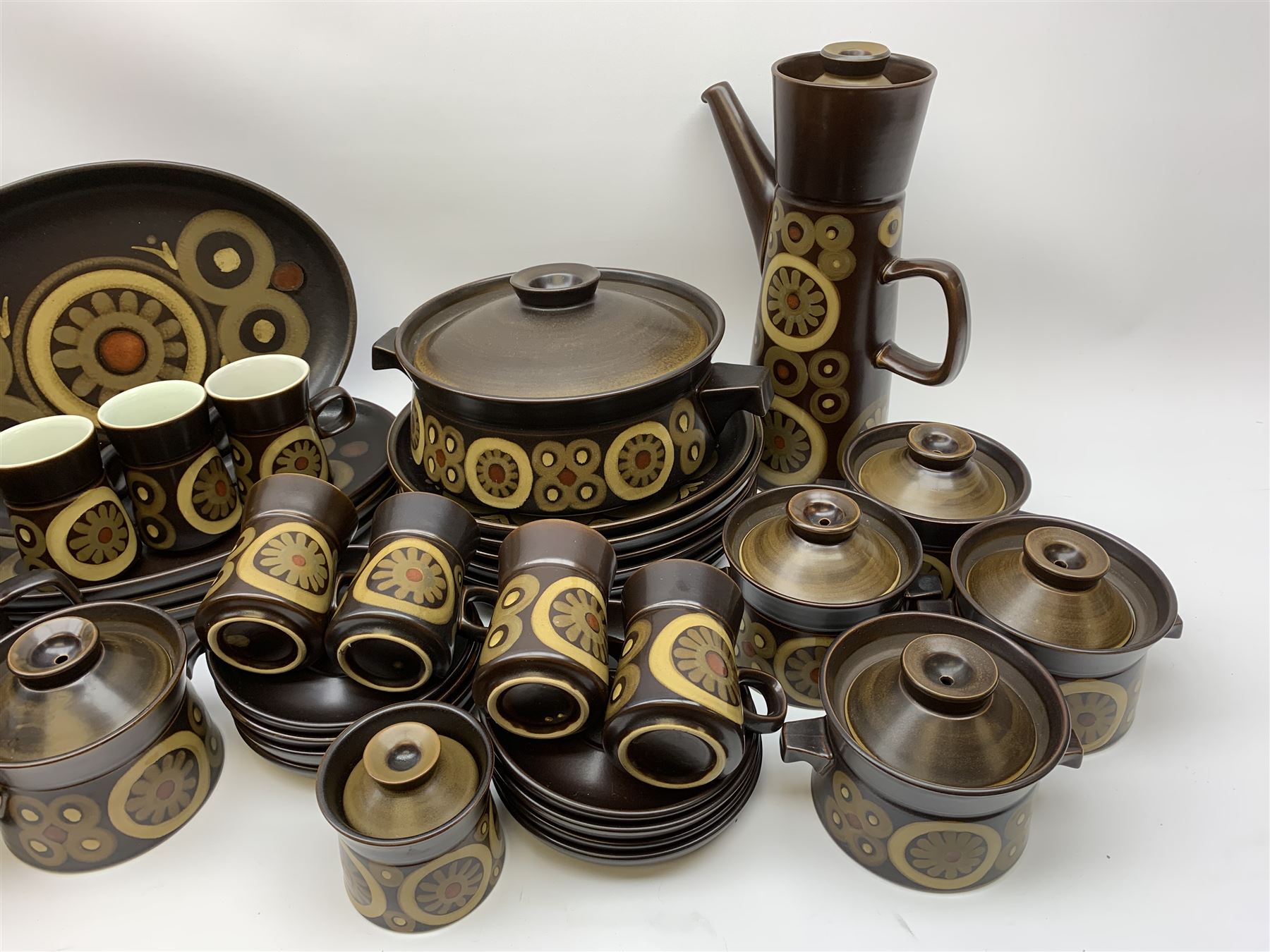 Denby Arabesque patter tea and dinner wares, comprising six dinner plates, twelve side plates, six twin handled bowls and covers, two tureen and covers, four oval serving platters, coffee pot, water jug, milk jug, cream jug, sucrier and cover, and eight coffee cans. 