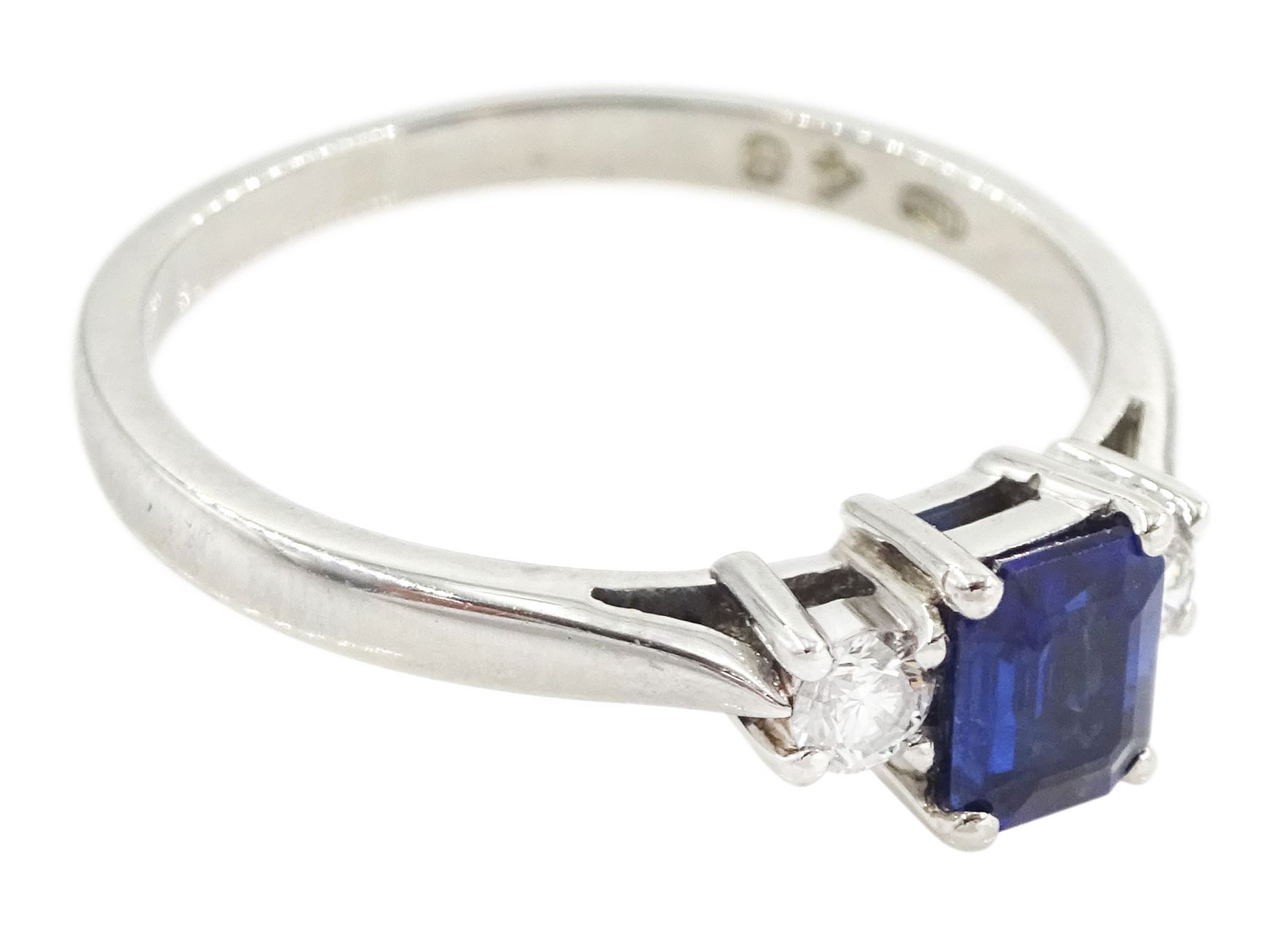 Platinum three stone emerald cut sapphire and round brilliant cut diamond ring, hallmarked, sapphire approx 0.50 carat, total diamond weight approx 0.15 carat
