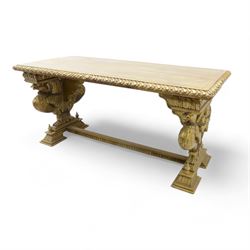 19th century Renaissance Revival carved and giltwood centre table, the rectangular top with gadrooned edge and carved frieze of repeating arched motifs with stylised scrolls, supported by a pair of carved winged griffin supports restrained by a central chained figure, on stepped rectangular bases united by carved stretcher