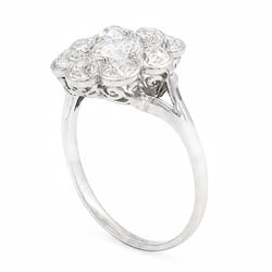 Early 20th century platinum diamond daisy flower head cluster ring, principal round cut diamond of approx 0.65 carat, surrounded by eight milgrain set old cut diamonds, within a pierced scroll design gallery, total diamond weight approx 2.15 carat