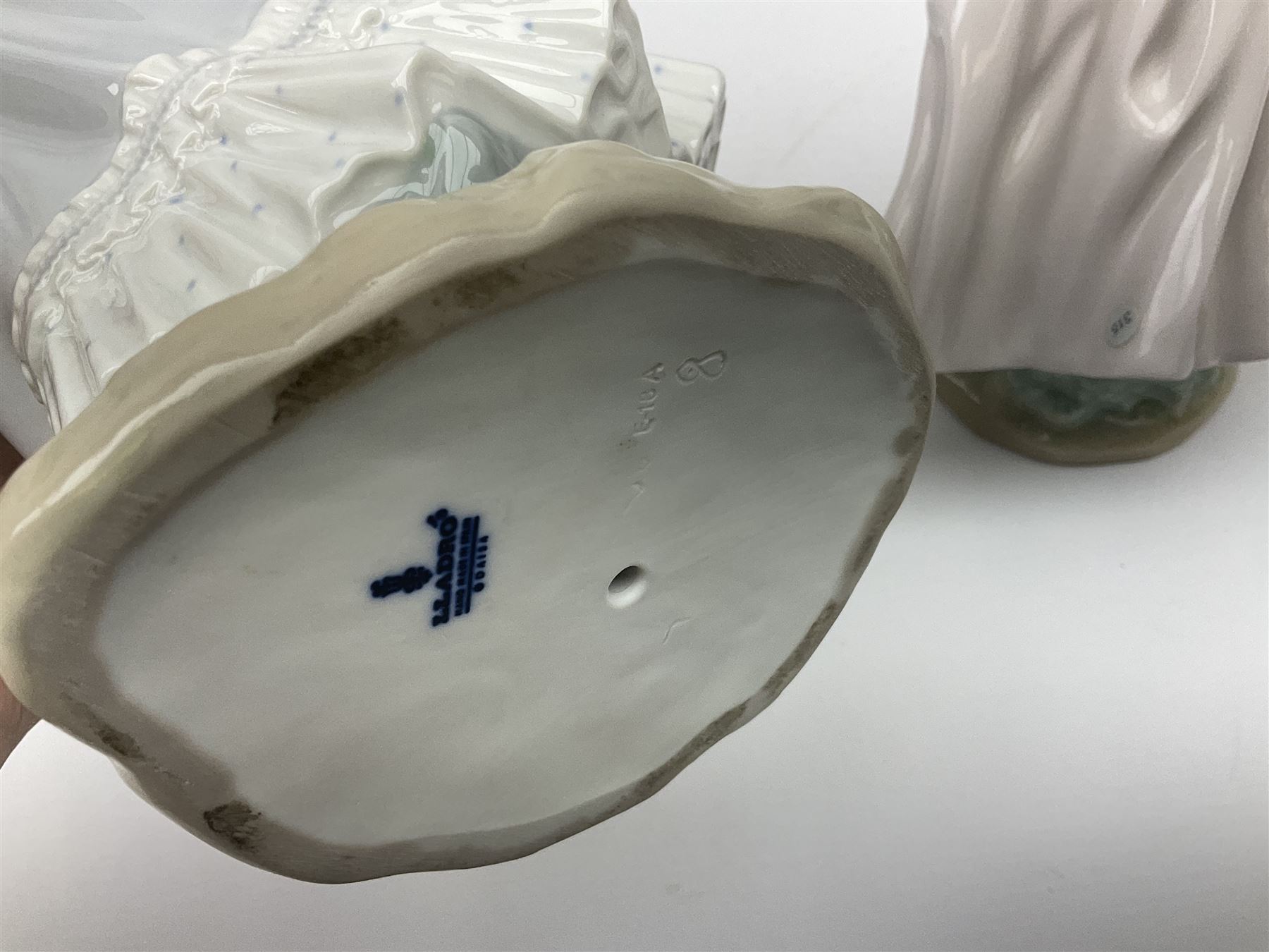 Three Lladro figures, comprising, Dreams of Summer Past no 6401, Spring Breeze no 4936 and Breezy Afternoon 5682 together with Lladro plaque Art Brings us Together no 7677, all in original boxes, largest example H35cm