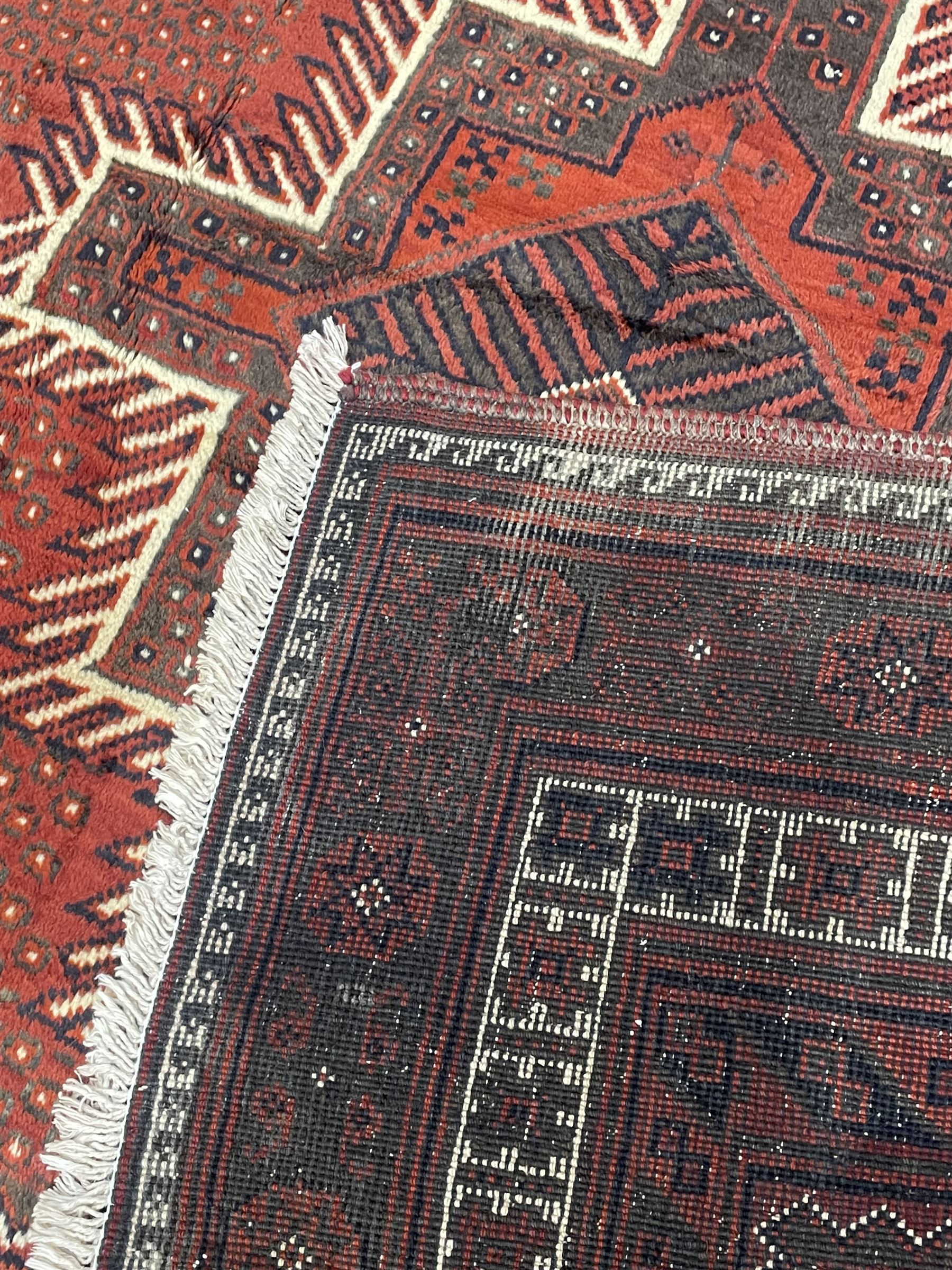 Persian Kelardasht red ground rug, the field decorated with two geometric medallions, multi-band border decorated with stylised flower heads and geometric repeating patterns