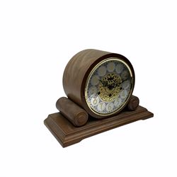 A 20th century  Westminster chime, spring driven three train “William Widdop” wall clock with a visible gridiron pendulum, chiming the hours and quarters on horizontal gong rods, white two-piece dial with roman numerals and minute track, steel spade hands, wooden case with full length glazed door and curved pediment with moulded cornice.
With key.
 
With a 20th century Westminster chime three train mantle clock with Hermle (German)  balance wheel movement chiming on four gong rods, ornate dial with Arabic numerals and minute track, contrasting black pierced steel hands, strike/silent lever.
H23cm W35cm D15cm