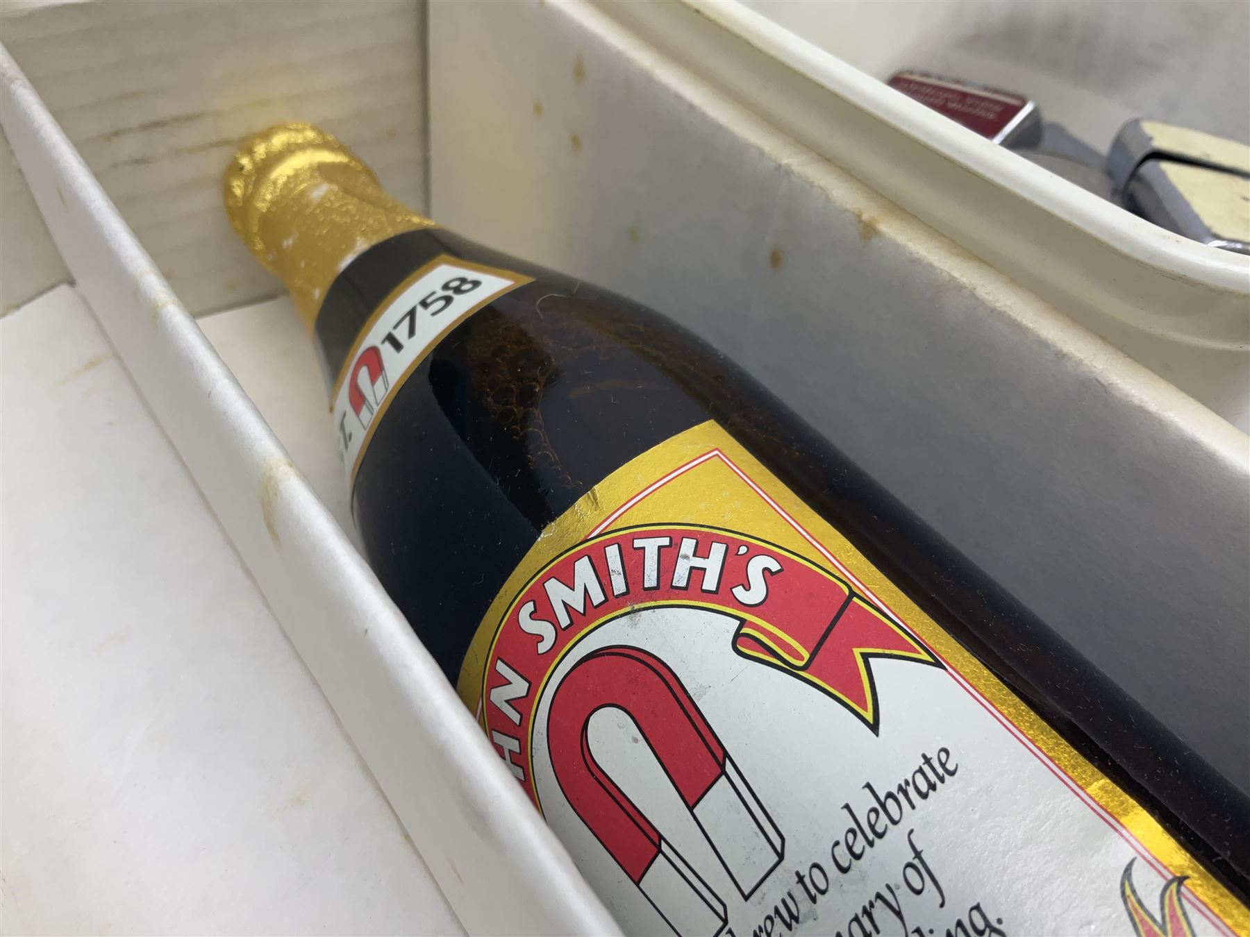 John Smiths presentation box commemorating 100 years of the Tadcaster brewery, containing two bottles of special brew and a glass, and a collection of lighters including Ronson and Jutson