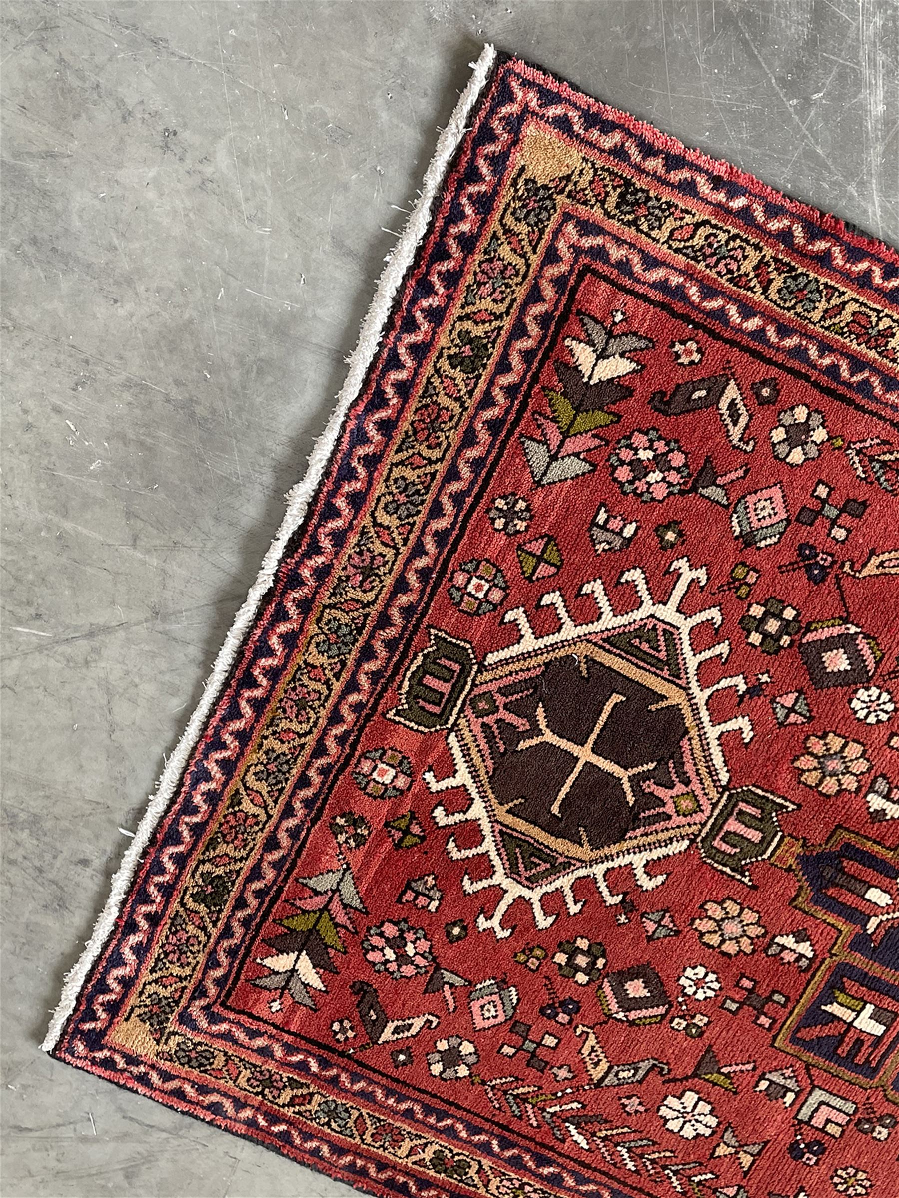 Persian Karajeh red ground runner, decorated with multiple stylised medallions and motifs