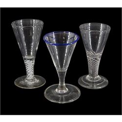 Three 18th century drinking glasses, the funnel bowls, one example with blue rim, upon varied stems, one example with single series air twist stem, another with double series opaque twist stem, and conical feet, two folded, tallest H11.5cm