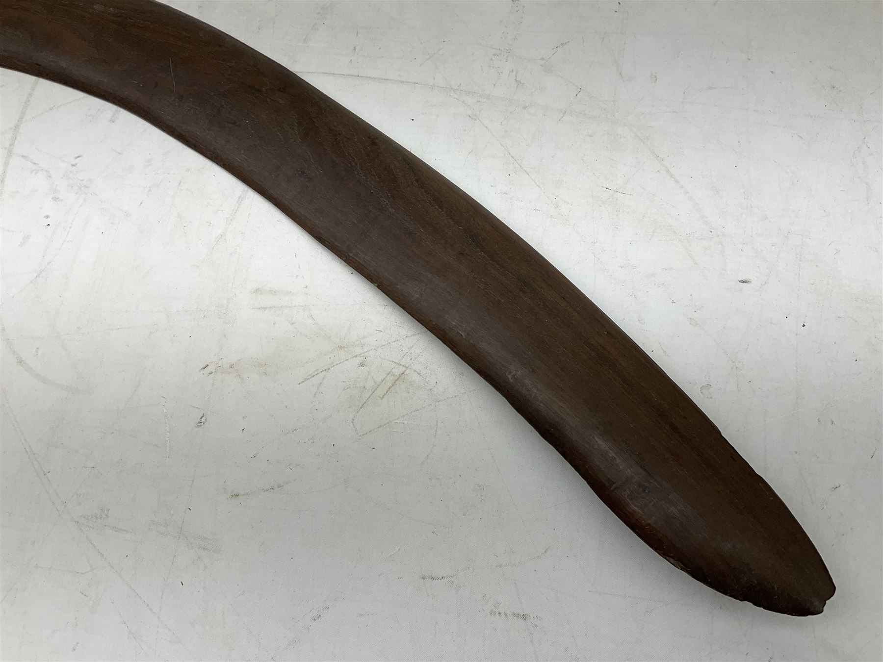 Australian aboriginal woomera spear thrower incised/carved with a wavy line and dots L69cm; and two boomerangs, one with carved geometric decoration (3)