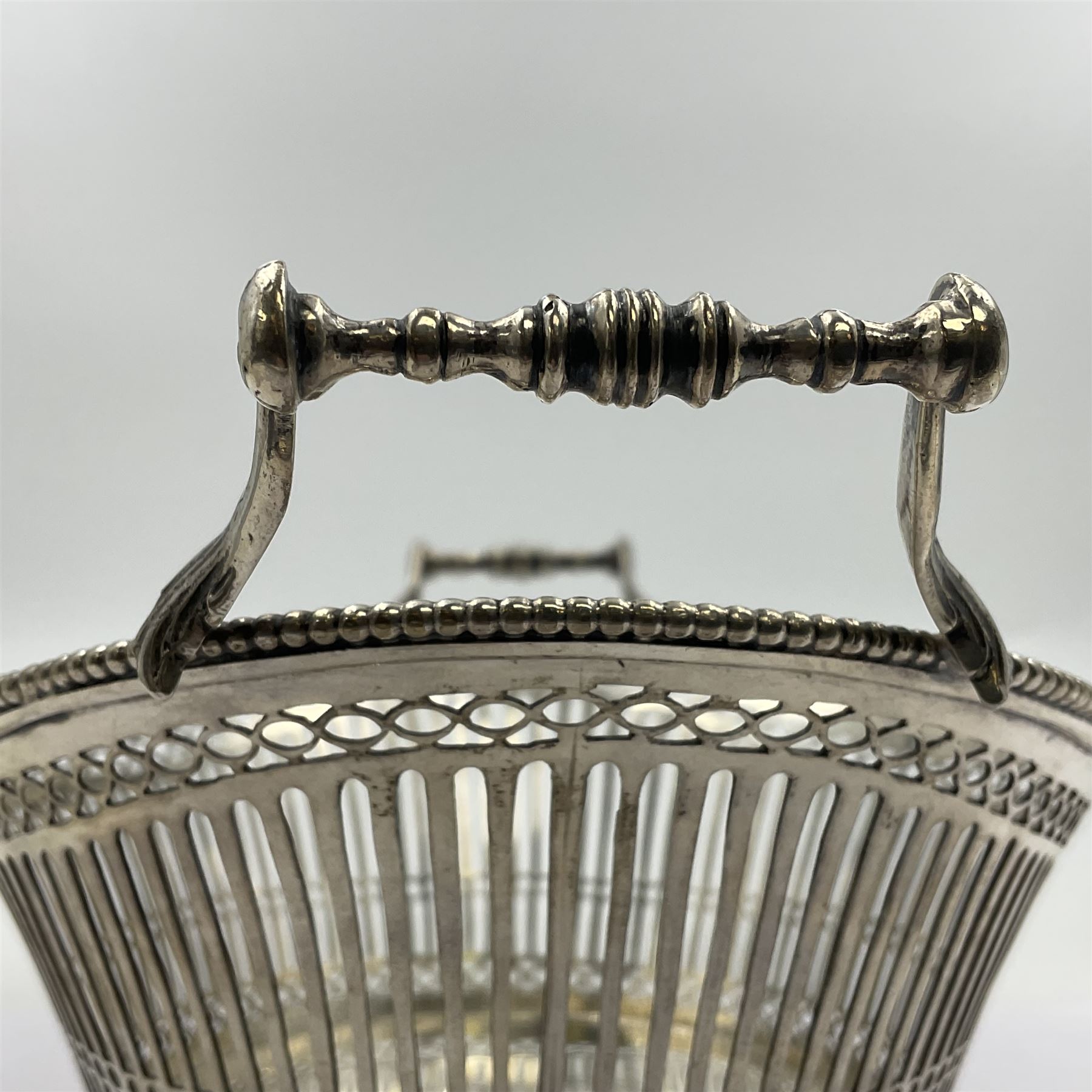 Early 20th century Dutch silver basket, of oval form with pierced sides, beaded rim, and twin handles, marked with Lion Passant for 2nd standard purity and date letter for 1910, other marks worn and indistinct, including handles H8.5cm L25.5cm