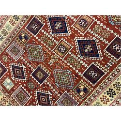 Turkish Kazak red ground rug, the field decorated with a combination of lozenge and square stylised motifs, repeating guarded border