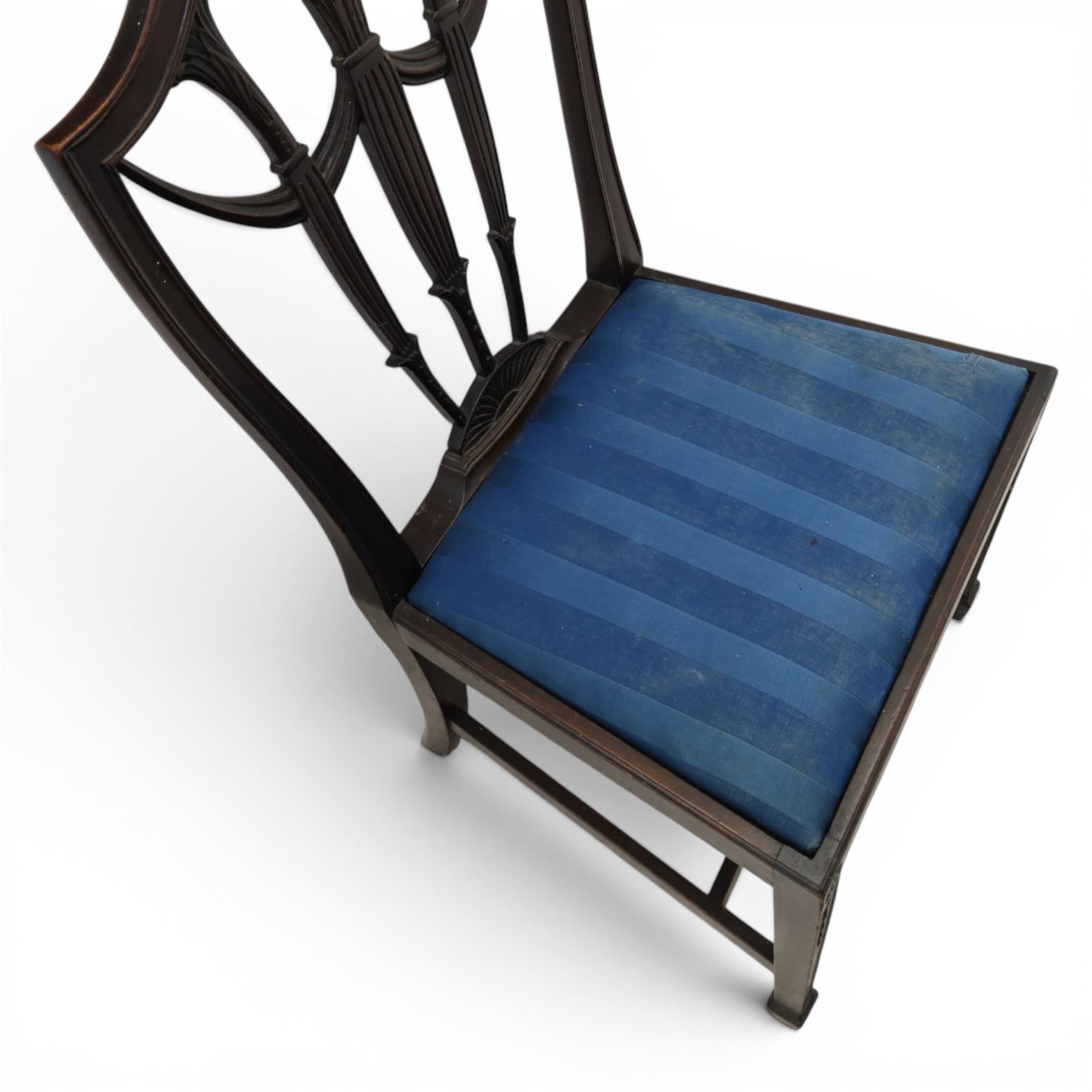 Set of eight George III style mahogany dining chairs, comprising two carvers and six singles, each with shaped top rail above pierced splay carved with feathers, with drop in stuffover seats upholstered in blue striped fabric, raised upon square tapering legs joined by stretchers, together with a mahogany twin pedestal dining table, the oval top with central leaf raised upon turned columns and splayed reeded legs terminating in lion paw feet and brass castors, 
