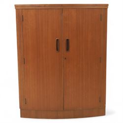 Turnbridge of London - Mid 20th century teak cocktail cabinet, with fold out top extending to 160cm, with twin doors revealing a shelved interior, the back with sliding glazed doors, raised on a recessed plinth base with castors