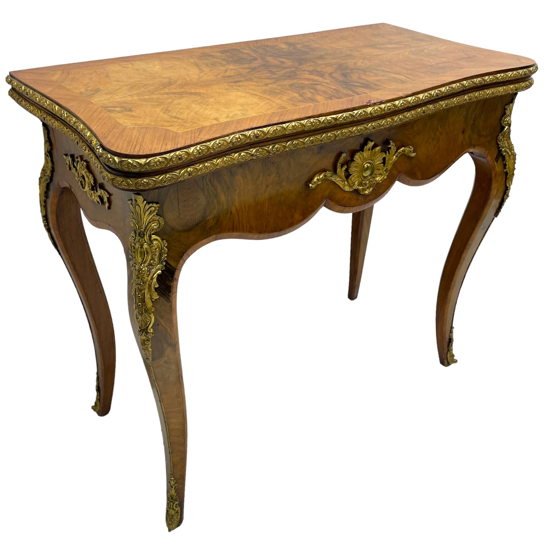 20th century French walnut and Kingwood card table, shaped fold-over top with figured quarter-matched veneers and floral egg and dart moulded edge in gilt metal, shaped aprons decorated with shell motifs with extending foliage, pull-out action base revealing storage well, on cabriole supports with ornate gilt metal mounts 