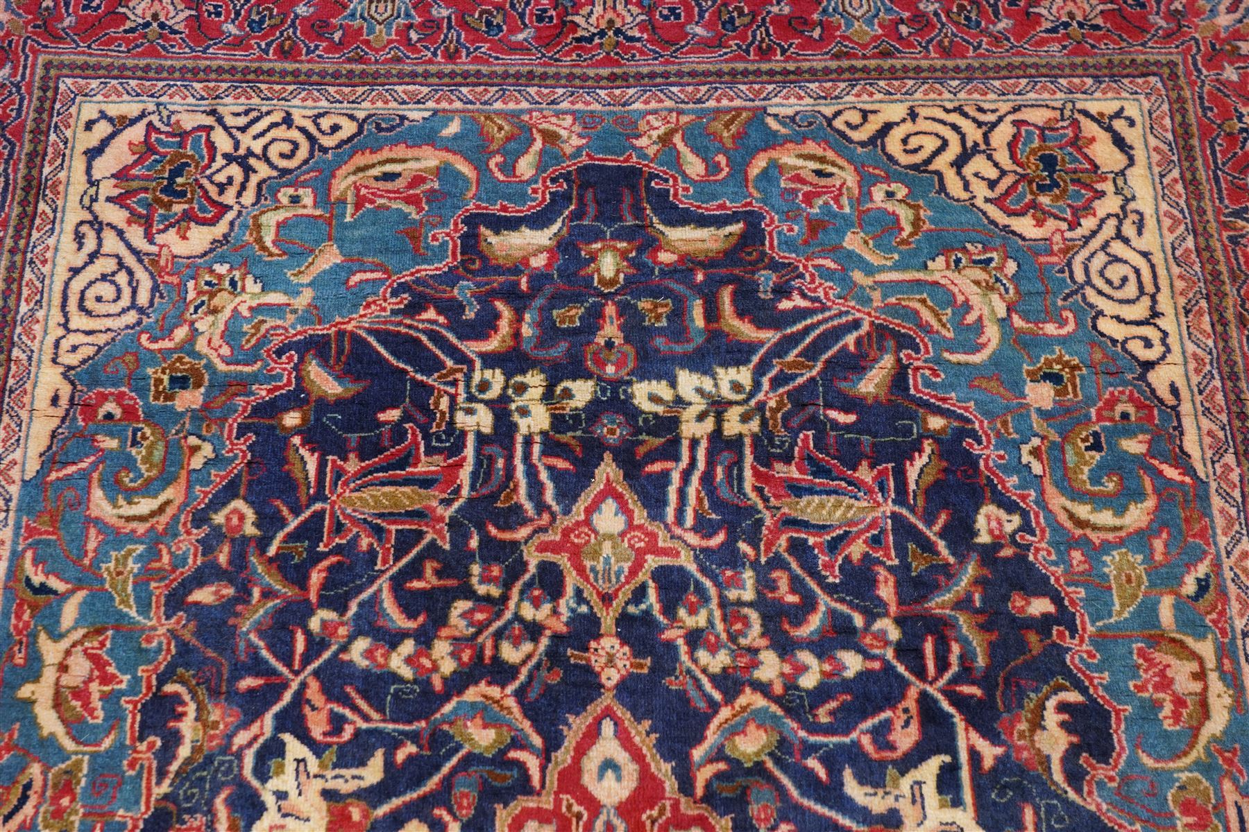 North West Persian Sarouk hand-knotted rug, indigo field with central stepped medallion with pendants, issuing an all-over arrangement of scrolling vinery, palmettes and stylized floral sprays, enclosed by a broad turquoise field of sinuous arabesques,, ivory spandrels with foliate decoration, madder red main border of stylized palmettes, and flowering vines, flanked by reciprocal guard stripes, cotton fringe ends 
