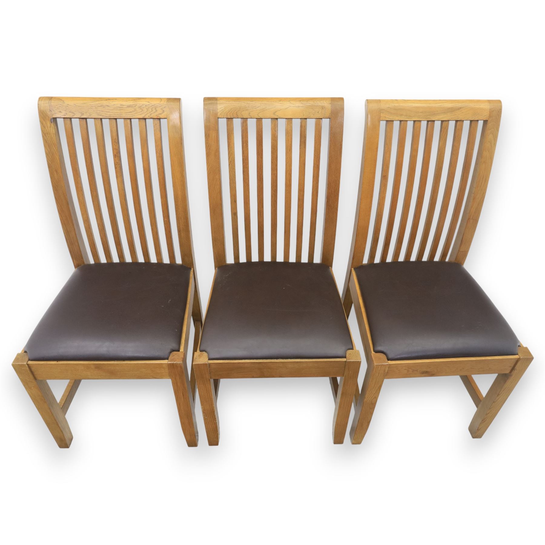 Contemporary oak extending dining table, moulded rectangular top with visible grain and inset extension leaf, pull out extending mechanism, standing on four square legs, accompanied by a set of high slat back chairs with upholstered brown faux leather seats and square tapering supports joined by stretchers