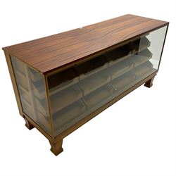 Early 20th century oak framed haberdashery shop counter, veneered top with glazed front and sides, fitted with sixteen graduating drawers with oak fronts and handles, raised on shaped supports