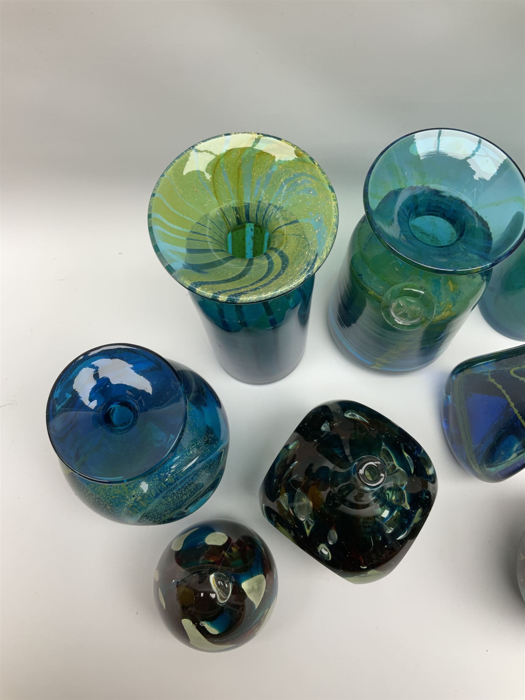 Quantity of M’dina art glass to include a streaked blue and green bottle form vase with captured bubble design and slender neck, H35cm, along with a paperweight, ovoid form vase and another vase all decorated in a blue, brown and white colour way, other contemporary glass examples etc with etched marks beneath