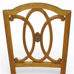 Edwardian pair of satinwood side chairs, each with shaped crest rail above an intertwining oval pierced splats centred by a floral patera, upholstered drop-in seats, raised on cabriole supports with applied floral mounts to the knees