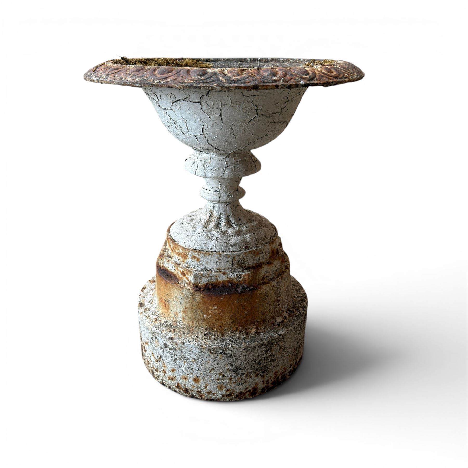 Victorian cast iron garden urn, egg and dart rim with shallow bowl, raised on stepped circular pedestal, finished in weathered white paint 