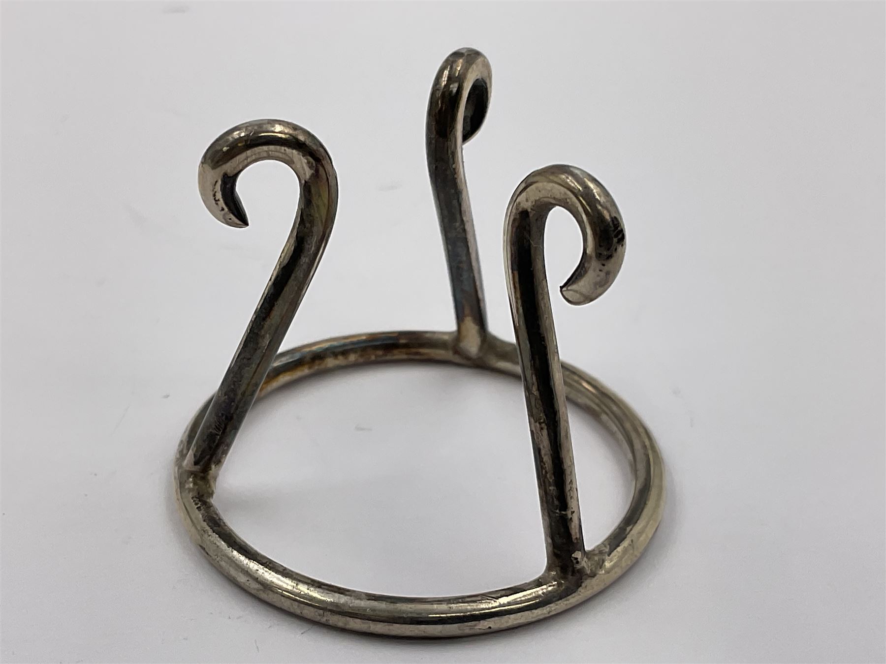 Modern silver limited edition Easter egg, no. 70/500, the gilt openwork body decorated with cascading bluebells and hinged cover with pierced circular panel set with a single faceted purple stone, opening to reveal a gilt interior, upon silver stand with three scrolling pad feet, each hallmarked St James House Company, London 1981, height including stand 8cm