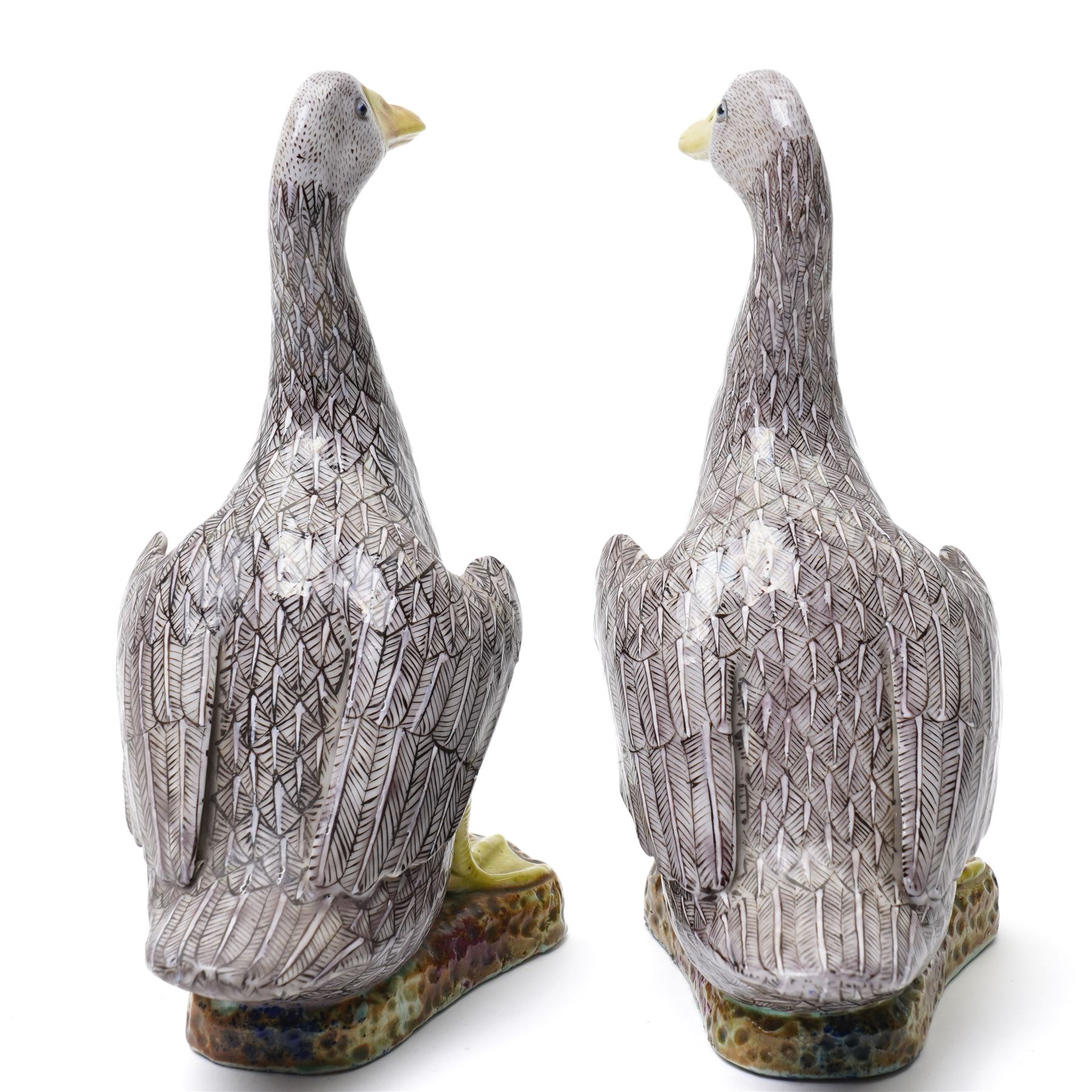 Pair of 20th century Chinese Export porcelain ducks, each naturalistically modelled with aubergine and white enamel plumage and seated on polychrome rockwork bases, H24cm 