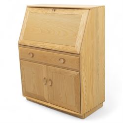 Ercol - light elm bureau, fitted with fall-front writing surface revealing adjustable shelving, above a single long drawer and twin cupboard doors, on plinth base
