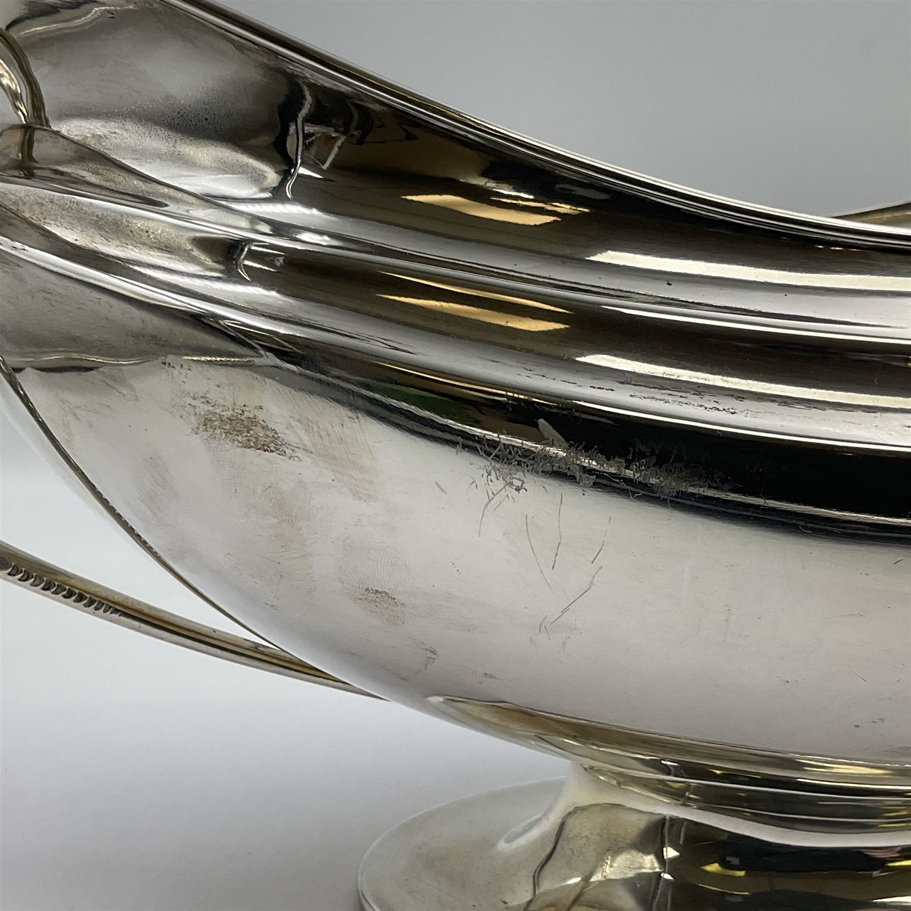 1920s silver twin-handled pedestal bowl, of navette form with twin bifurcated acanthus capped scroll handles, engraved with initial R to body and upon spreading oval foot, hallmarked Hawksworth, Eyre & Co Ltd, Sheffield 1925, including handles H21.8cm