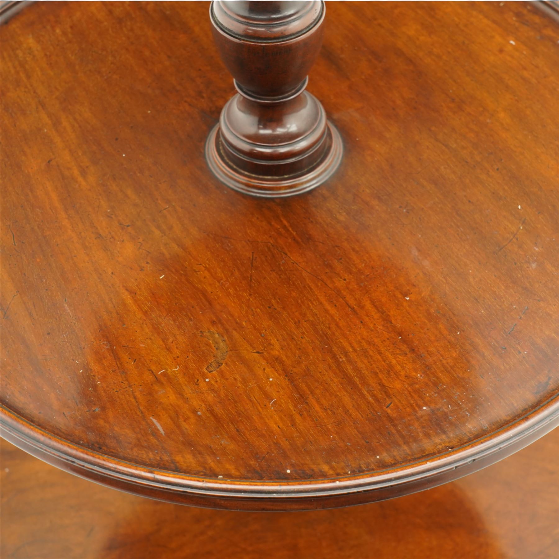 George III mahogany dumb waiter, three graduating circular tiers with moulded edges, turned column supports on tripod base, on castors 